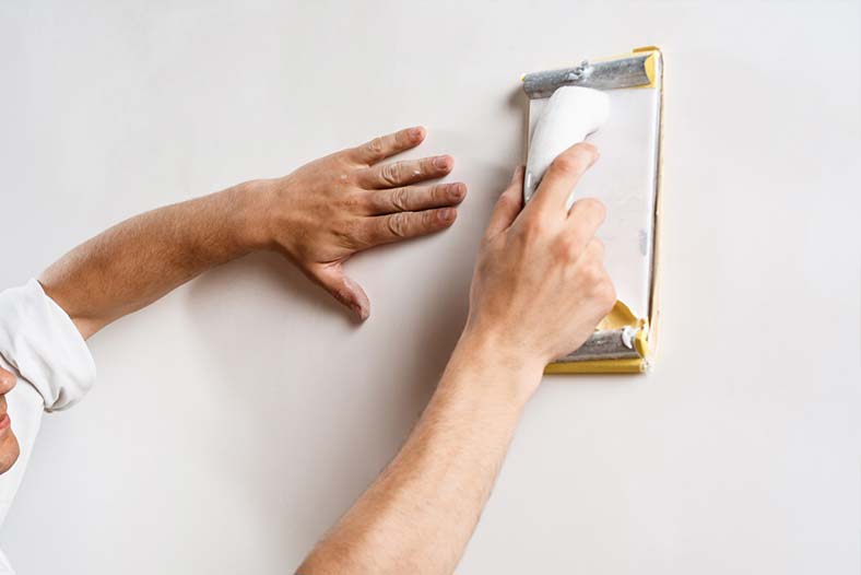 Personne qui ponce un mur